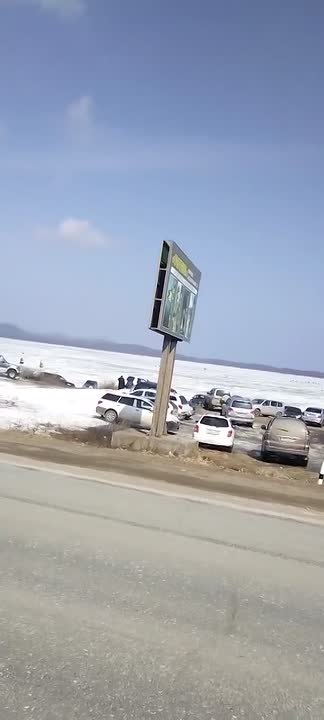 Опасно припарковались: информационный щит может свалиться на машины сахалинских рыбаков из-за сильного ветра